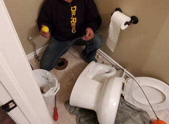 a picture of a toilet and a plumber